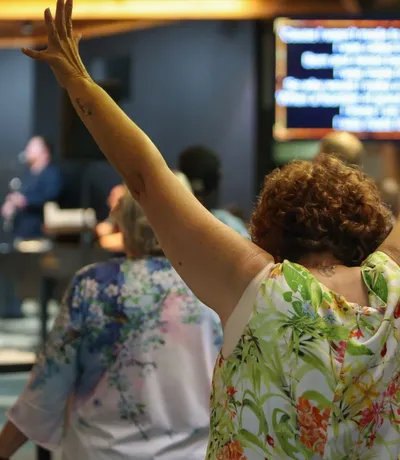 Hands raised across a row of the congregation