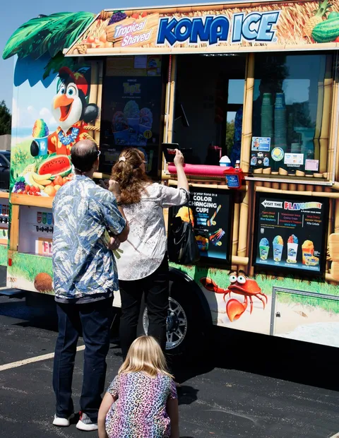 Families queueing at the shaved ice truck on the church lot
