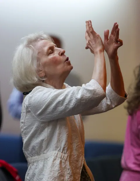 A woman worshipping with her hands raised during a gathering