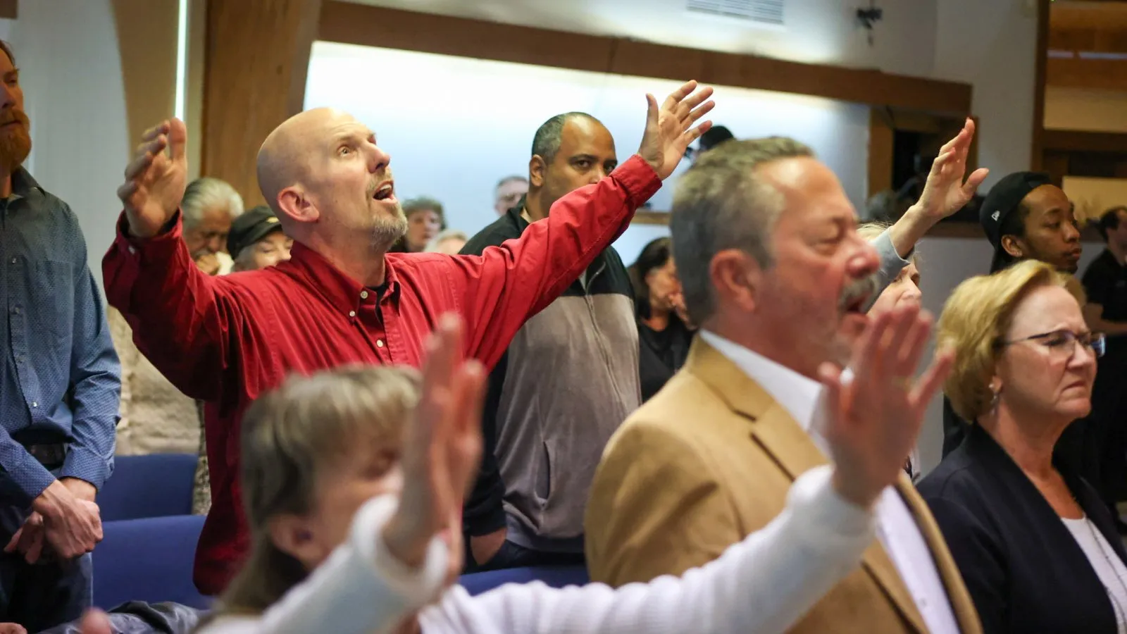The congregation worshipping with hands raised on a Sunday morning